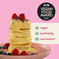 Stapel Pancakes mit Toppings, daneben der PETA Vegan Food Award 2023 und die Claims 'vegan', 'nachhaltig', 'convenient' - SEO-optimiert für Reoat.